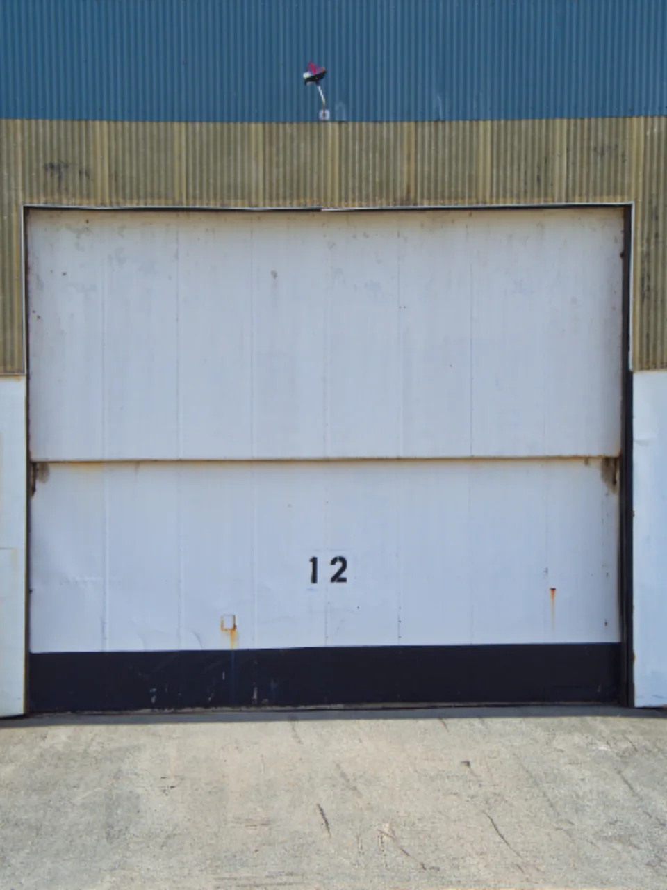 a white sectional garage door with the number 12 above it